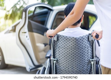 Caregiver helping senior handicapped asian woman from wheelchair get into car - Powered by Shutterstock