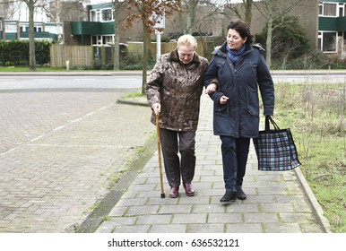 A Caregiver Helps An Older Woman With Groceries