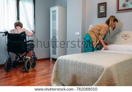 Similar – Caregiver making bed of elderly patient in nursing home