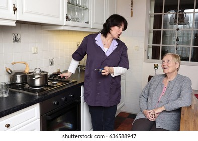 A Caregiver Is Making Soup For An Elderly Woman