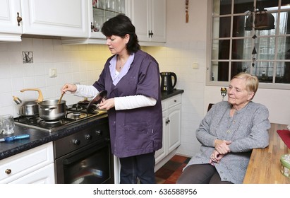 A Caregiver Is Making Soup For An Elderly Woman