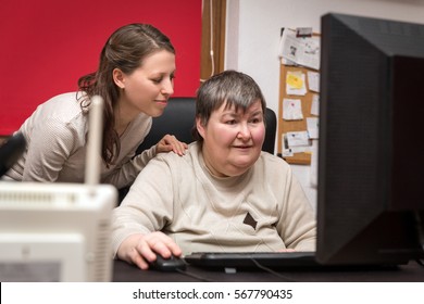 caregiver and mentally disabled woman learning at the computer, special education