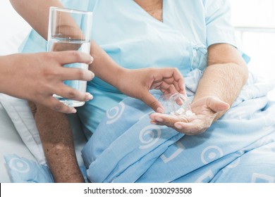 Caregiver Nurse Helping Elderly Woman Taking Medicine On The Bed And Check Up After Admit Inpatient In Hospital.