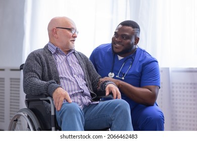 Caregiver and old man in a wheelchair. Professional nurse and patient in a nursing home. Assistance, rehabilitation and health care.