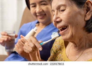 Caregiver take care asian elderly woman while brush teeth. - Powered by Shutterstock