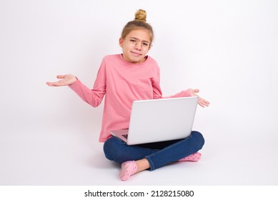 Careless Attractive Beautiful Caucasian Teen Girl Sitting With Laptop In Lotus Position On White Background Shrugging Shoulders, Oops.