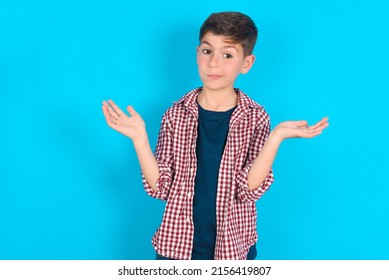 Careless Attractive Caucasian Kid Boy Wearing Plaid Shirt Over Blue Background Shrugging Shoulders, Oops.