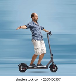 Careless Man Riding An Electric Scooter Hands Free, He Is Balacing With Open Arms