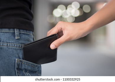 Careless Woman Being Pick Pocketed; Woman Facing Risk Of Urban Crime Of Pickpocket Or Pickpocketing With Hand Of Thief Stealing Her Wallet; Urban Danger Or Risk Concept; Asian Young Adult Women Mode