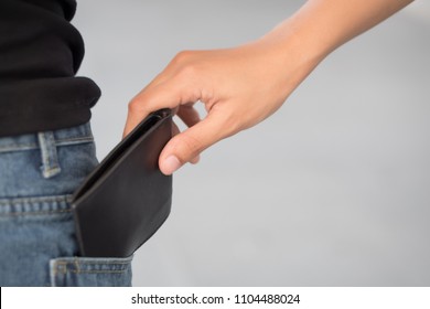 Careless Woman Being Pick Pocketed; Woman Facing Risk Of Urban Crime Of Pickpocket Or Pickpocketing With Hand Of Thief Stealing Her Wallet; Urban Danger Or Risk Concept; Asian Young Adult Women Mode