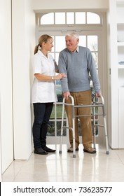 Carer Helping Elderly Senior Man Using Walking Frame