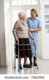 Carer Helping Elderly Senior Woman Using Walking Frame