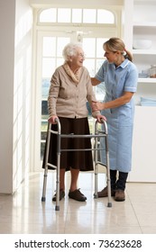 Carer Helping Elderly Senior Woman Using Walking Frame