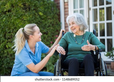 Carer Pushing Senior Woman In Wheelchair Outside Home - Shutterstock ID 1148689052