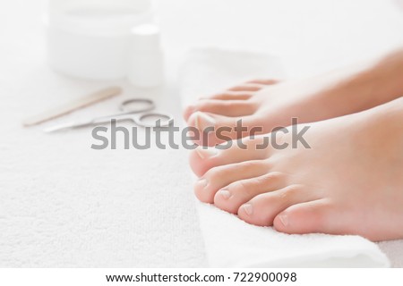 Cares about woman's feet nails. Pedicure, manicure beauty salon concept. Scissors and nail file on the white towel.