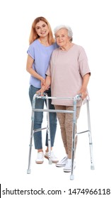 Caretaker Helping Elderly Woman With Walking Frame On White Background