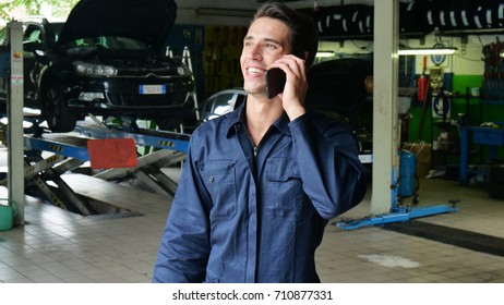 In A Caretaker A Mechanic Uses The Phone To Respond To Customer Messages And Calls As A Car Customer. Concept Of: Warranty, Security, Insurance And Assistance, Reviews, Technology And Customer Care.