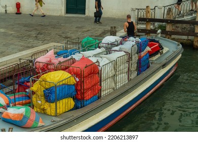 Cargo boat with multi-colored bags at the edge of the street in Venice, transportation of goods by water transport on the Venetian streets, cargo transportation in the city of Venice - Shutterstock ID 2206213897