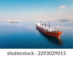Cargo bulker grain ship waiting uploading stay at anchor near port. Aerial shot