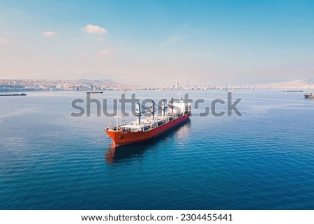 Cargo bulker ship waiting uploading stay at anchor near port. Aerial shot