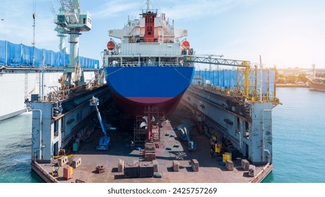 Cargo container ship at dry dock concept maintenance service. working at dry dock. Insurance and Maintenance Crude tanker Ship concept. Freight Forwarding Service maintenance Insurance.	