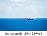 Cargo container ship sailing through calm Atlantic Ocean.