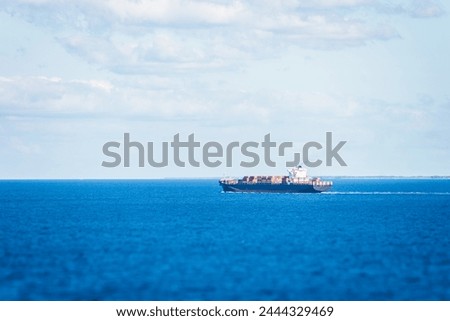 Cargo container ship sailing through calm Atlantic Ocean.