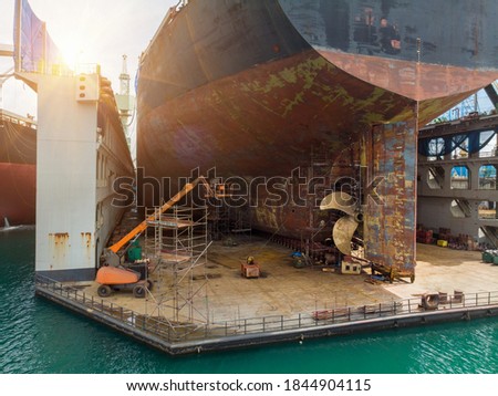 Cargo container ship stern with propeller at drydock for maintenance follow annual plan and service.