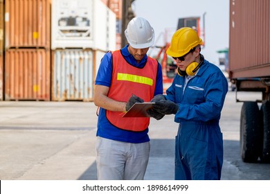 Frachtcontainer-Mitarbeiter und Ingenieur diskutieren zusammen mit Daten im Dokument auf der Zwischenablage und halten sich in der Nähe von LKW im Arbeitsbereich. Business Logistics importiert Exportversandkonzept.
