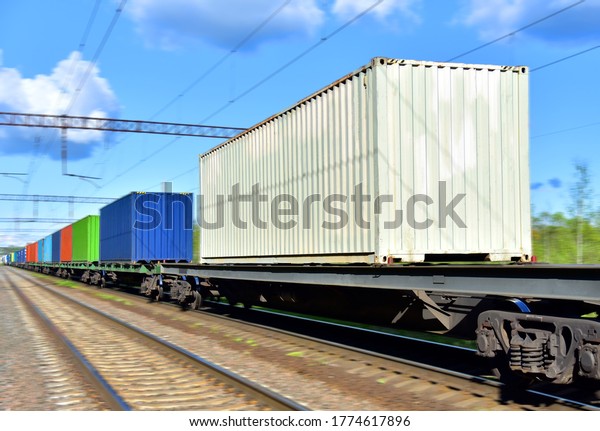 Cargo Containers\
Transportation On Freight Train By Railway. Intermodal Container On\
Train Car. Rail Freight Shipping Logistics Concept. Out of focus,\
object in motion.