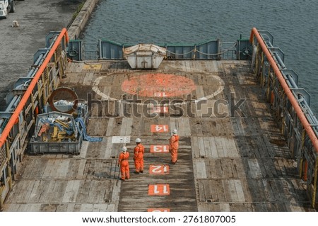 The cargo deck of the offshore support vessel with some deck cargo and the garbage basket. Vessel has arrived to port, alongside jetty, to discharge deck cargo and receive new for further delivery to an offshore installation (oil rig)