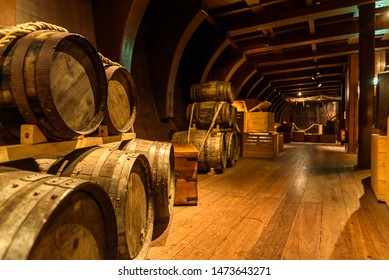 Cargo hold of a wooden sail ship with barrels in the foreground