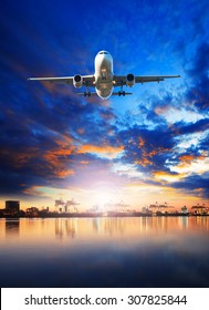 Cargo Plane Flying Against Blue Sky And Shipping Port Behind