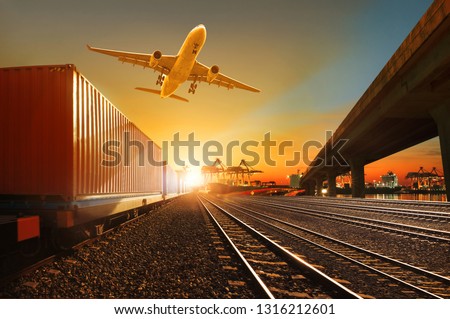 cargo plane flying over container trains and commercial shipyard background