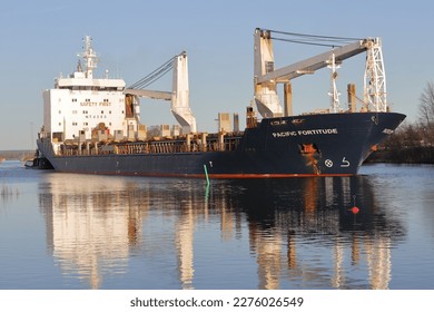 Cargo ship arriving on a sunny day - Shutterstock ID 2276026549