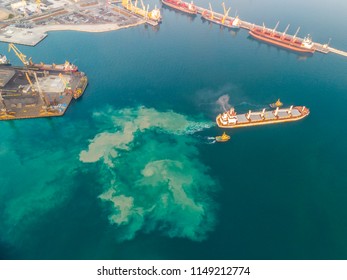 The Cargo Ship Leaves The Side Leaving A Dirty Oily Stain Behind It. Aerial View