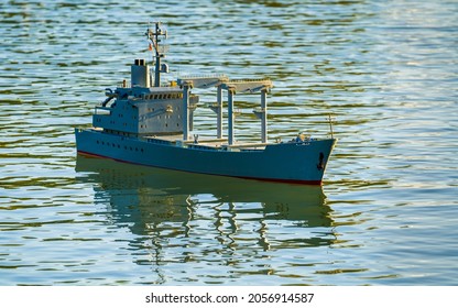 Cargo Ship Model Swimming On Lake, Reflections On Water