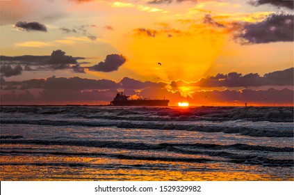 Cargo Ship On The Horizon. Vessel In Sunset