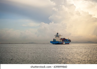 Cargo Ship Sailing Away Against Sunrise