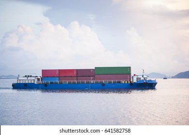 Cargo Ship Sailing Away Against Sunrise