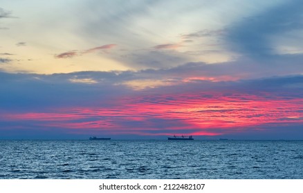 Cargo Ship Is At Sea On The Roadstead At Sunset