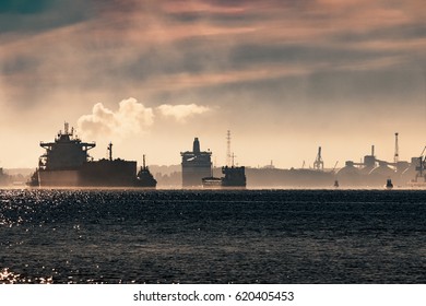 Cargo ship silhouette entering a port of Riga at the morning - Shutterstock ID 620405453