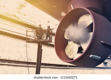 Cargo Ship Under Repair By Jet High Pressure Water Jet On Propeller Of Ship To Cleaning Before Blasting And Planting In Shipyard On Monochrome