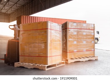 Cargo Shipment Loading For Truck. Freight Trailer Truck For Delivery Service. Warehouse Dock Load Cargo Into Shipping Container. Stacked Boxes Wrapped Plastic On Pallet Rack. Logistics Cargo Transport