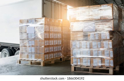 Cargo shipment loading for truck.Stacked of package boxes wrapping plastic on pallet waiting to load into shipping container. Cargo shipment boxes, Freight truck, Warehousing. Logistics and transport.