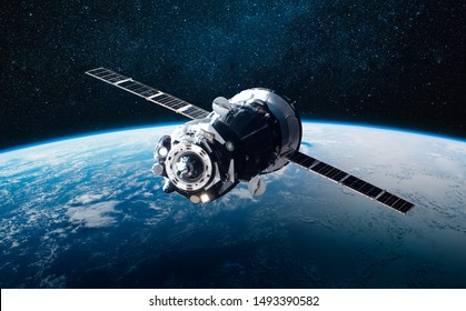 Cargo space craft and Earth planet. Dark background. Sci-fi wallpaper. Elements of this image furnished by NASA