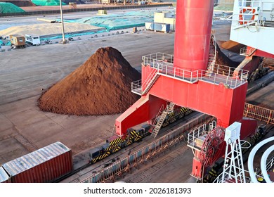 Cargo terminal for unloading bulk cargo of iron ore by shore cranes and grabs. Views of cargo equipments, tractors and grabs for transshipment of bulk cargoes. Huludao, China, November, 2020. - Shutterstock ID 2026181393
