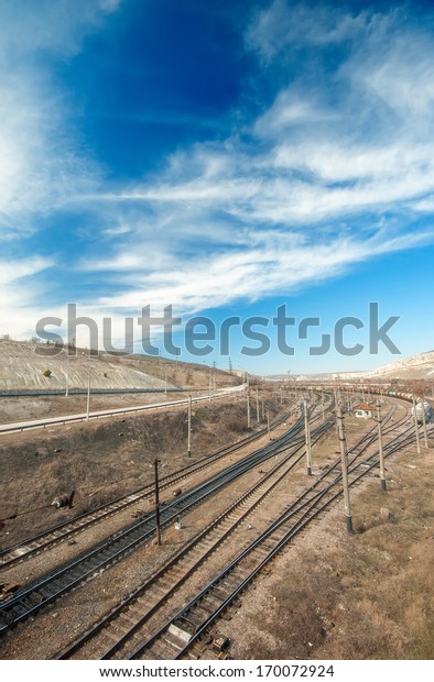 Cargo train station and rails stretching into\
the distance