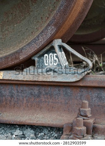 Cargo train wheel resting securely on brake chock preventing movement along railway lines