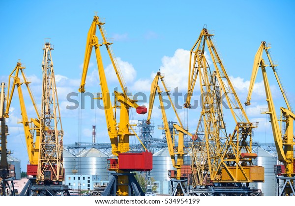 cargo transportation concept - industrial sea\
port and cranes, railways,\
warehouses